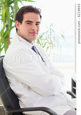 Side view of doctor sitting with arms folded Side view of doctor sitting with arms folded 6219693