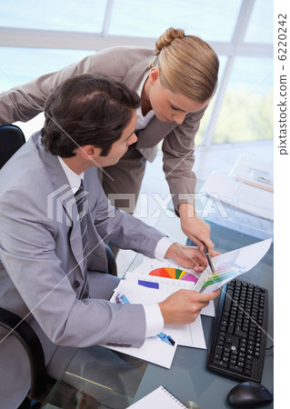 Portrait of a manager pointing at something to her employee on a 6220242