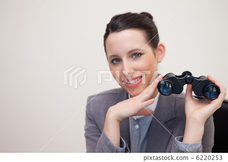 Smiling businesswoman with binoculars 6220253