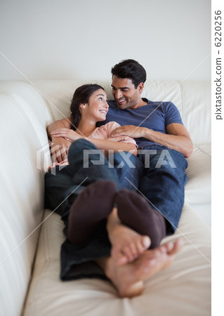 Portrait of a young couple lying on a sofa Portrait of a young couple lying on a sofa 6220256