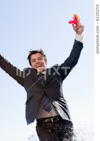Portrait of a businessman jumping in a swimming pool 6220258