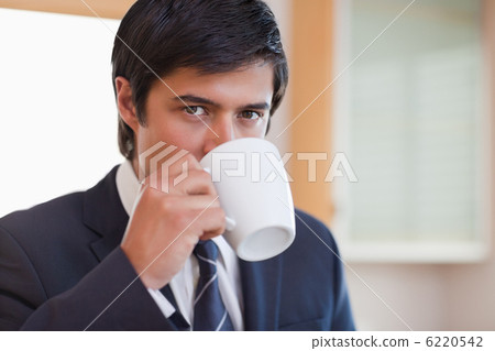 Close up of a businessman drinking coffee Close up of a businessman drinking coffee 6220542