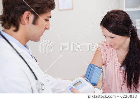 Male doctor taking female patients blood pressure Male doctor taking female patients blood pressure 6220838