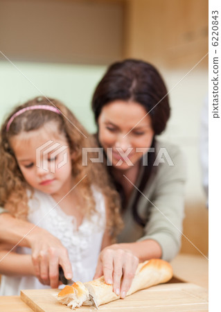 Mother and daughter cutting bread Mother and daughter cutting bread 6220843