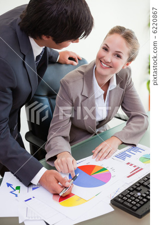 Portrait of a smiling business team studying statistics Portrait of a smiling business team studying statistics 6220867