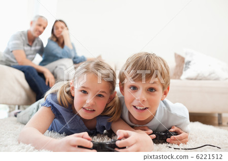Playful children playing video games with their parents on the b 6221512
