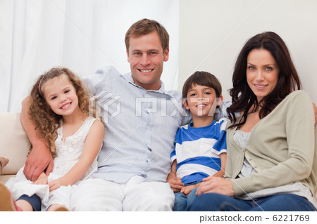 Family sitting on the sofa together 6221769