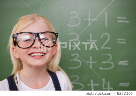 Smart schoolgirl posing in front of a blackboard 6222105
