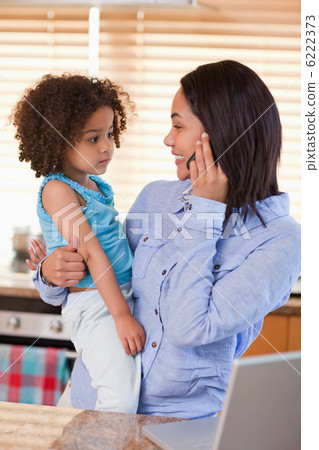 Mother and daughter using cellphone in the kitchen 6222373