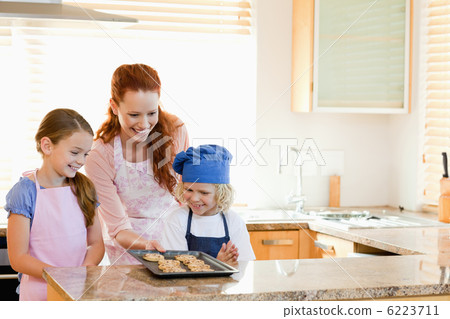 Mother presenting finished cookies to her children Mother presenting finished cookies to her children 6223711