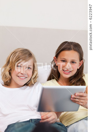 Brother and sister using tablet on couch 6223947