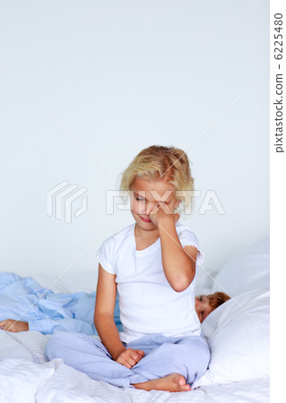 Tired girl sitting on the bed Tired girl sitting on the bed 6225480