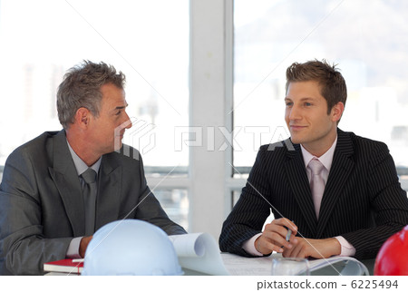 Two colleagues talking together at desk 6225494