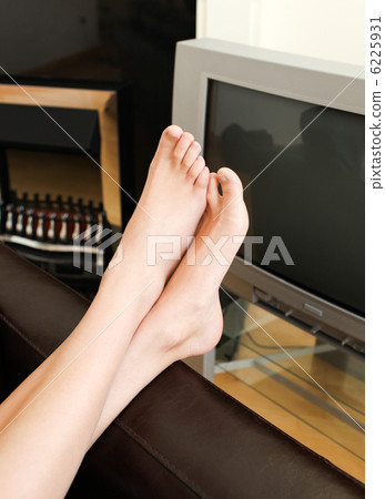 Unwound woman lies on sofa and watches TV 6225931