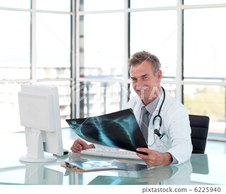 Serious male doctor holding a x-ray Serious male doctor holding a x-ray 6225940