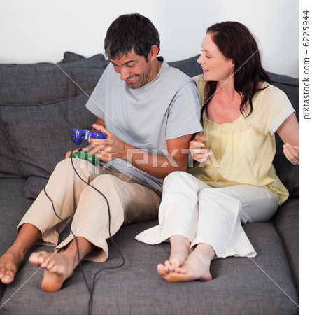Young couple on the sofa playing video games Young couple on the sofa playing video games 6225944