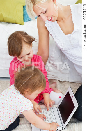 Cute family having fun with a laptop in the living-room 6225946