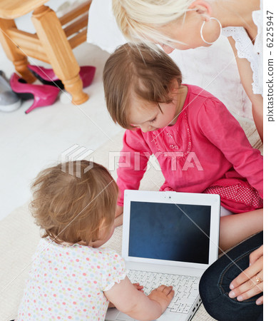 Radiant family having fun with a laptop in the living-room Radiant family having fun with a laptop in the living-room 6225947