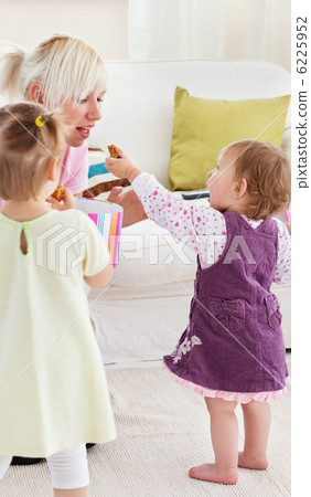 Smiling having fun with her girls in the living-room Smiling having fun with her girls in the living-room 6225952