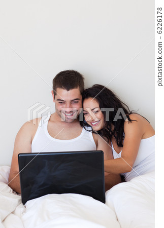 Smiling couple relaxing on their bed at home Smiling couple relaxing on their bed at home 6226178