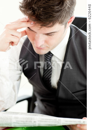 Concentrated businessman reading a newspaper Concentrated businessman reading a newspaper 6226448