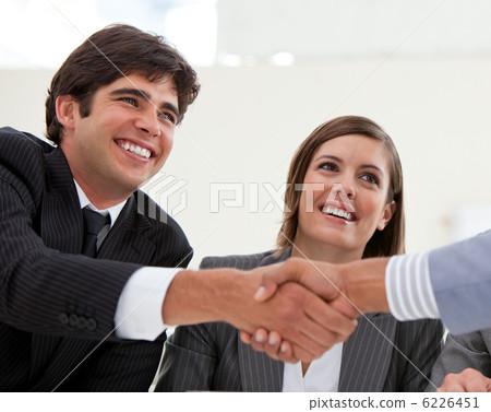 Smiling businessman and his colleague closing a deal with a part 6226451