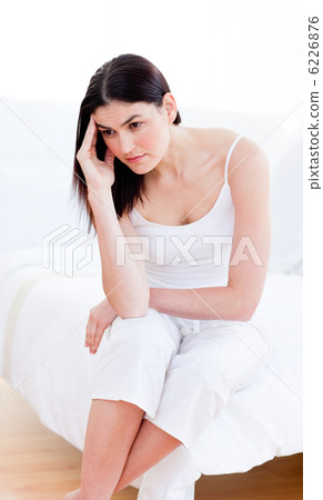 Portrait of a unhappy woman sitting on bed 6226876