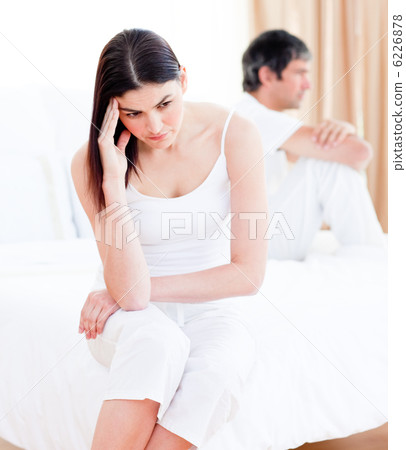 Upset couple having an argument sitting on bed 6226878