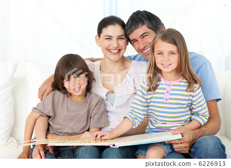 Joyful family reading together on the sofa 6226913