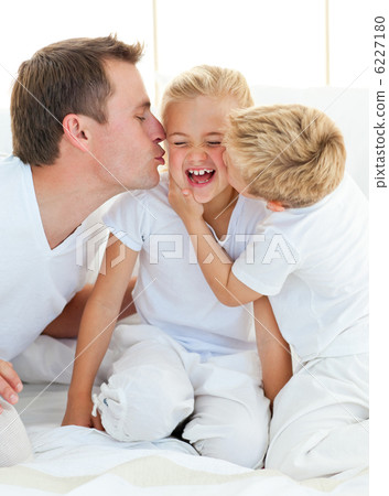 Loving family playing sitting on a bed Loving family playing sitting on a bed 6227180