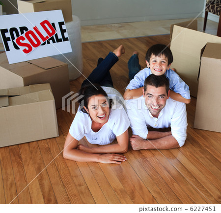 Family moving house on floor smiling at the camera 6227451