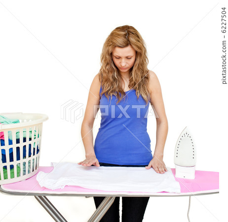 Concentrated woman behind an ironing board 6227504