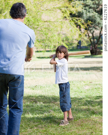 Jolly little boy playing baseball with his father 6227619