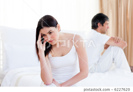 Angry couple having an argument sitting on bed 6227620