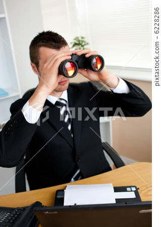 Concentrated young businessman looking through binoluars Concentrated young businessman looking through binoluars 6228286