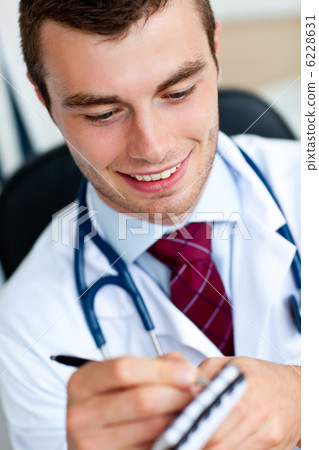 Caucasian male doctor writing a perscription 6228631