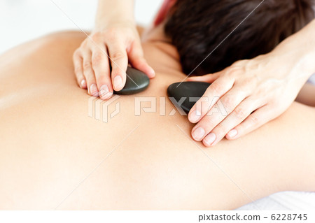Close-up of a man with hot stone on his back Close-up of a man with hot stone on his back 6228745