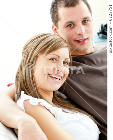 Portrait of a hugging couple sitting on a sofa 6228751