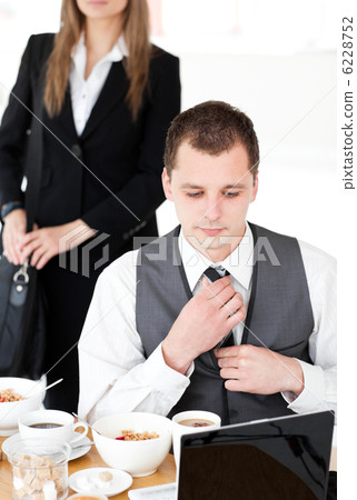 Charming businesswoman standing in the background while her husb Charming businesswoman standing in the background while her husb 6228752
