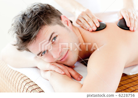 Handsome man receiving a back massage with hot stone 6228756