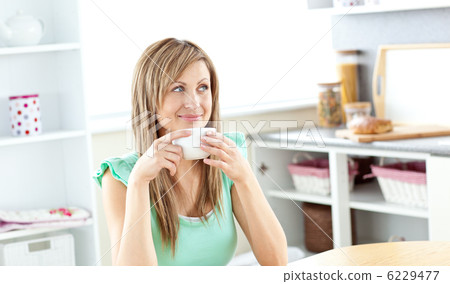Blond caucasian woman drinking coffee in the kitchen 6229477