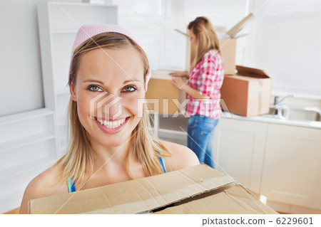 Two positive women carrying boxes at home 6229601