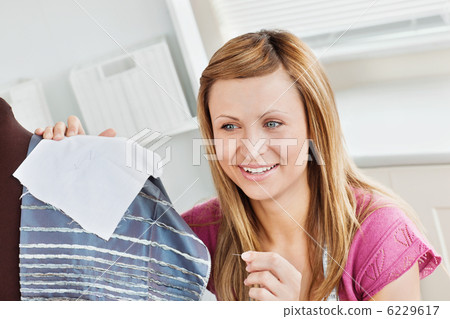 Positive young woman sewing clothes at home 6229617