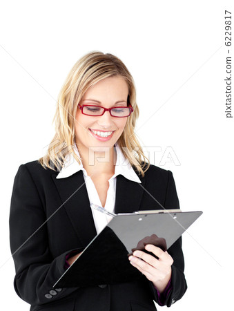 Serious businesswoman wearing glasses taking notes in her clipbo 6229817