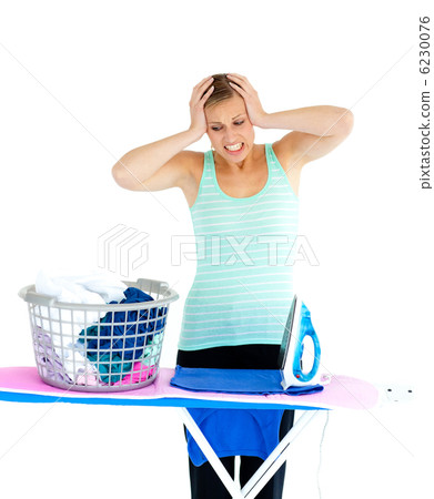 Unhappy woman ironing her clothes Unhappy woman ironing her clothes 6230076