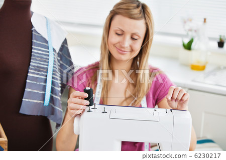 Bright young woman using her sewing machine Bright young woman using her sewing machine 6230217