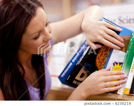 Pretty young woman looking for a book Pretty young woman looking for a book 6230219