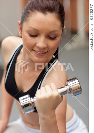 Portrait of a beautiful woman working out with dumbbells Portrait of a beautiful woman working out with dumbbells 6230277
