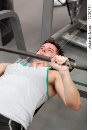 Muscular man working out with dumbbells Muscular man working out with dumbbells 6230284