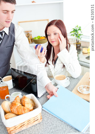 Couple of businesspeople having breakfast in the kitchen 6230531
